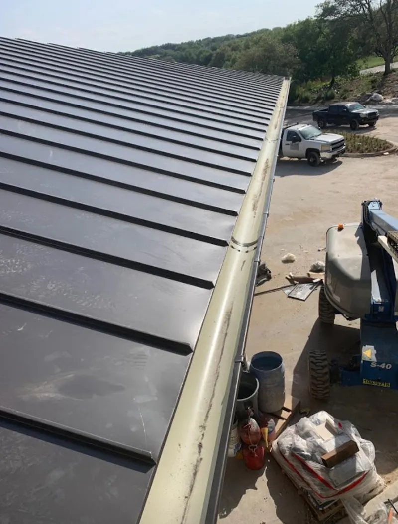 Standing seam panel and gutter detail on a metal roofing jobsite in Van Alstyne